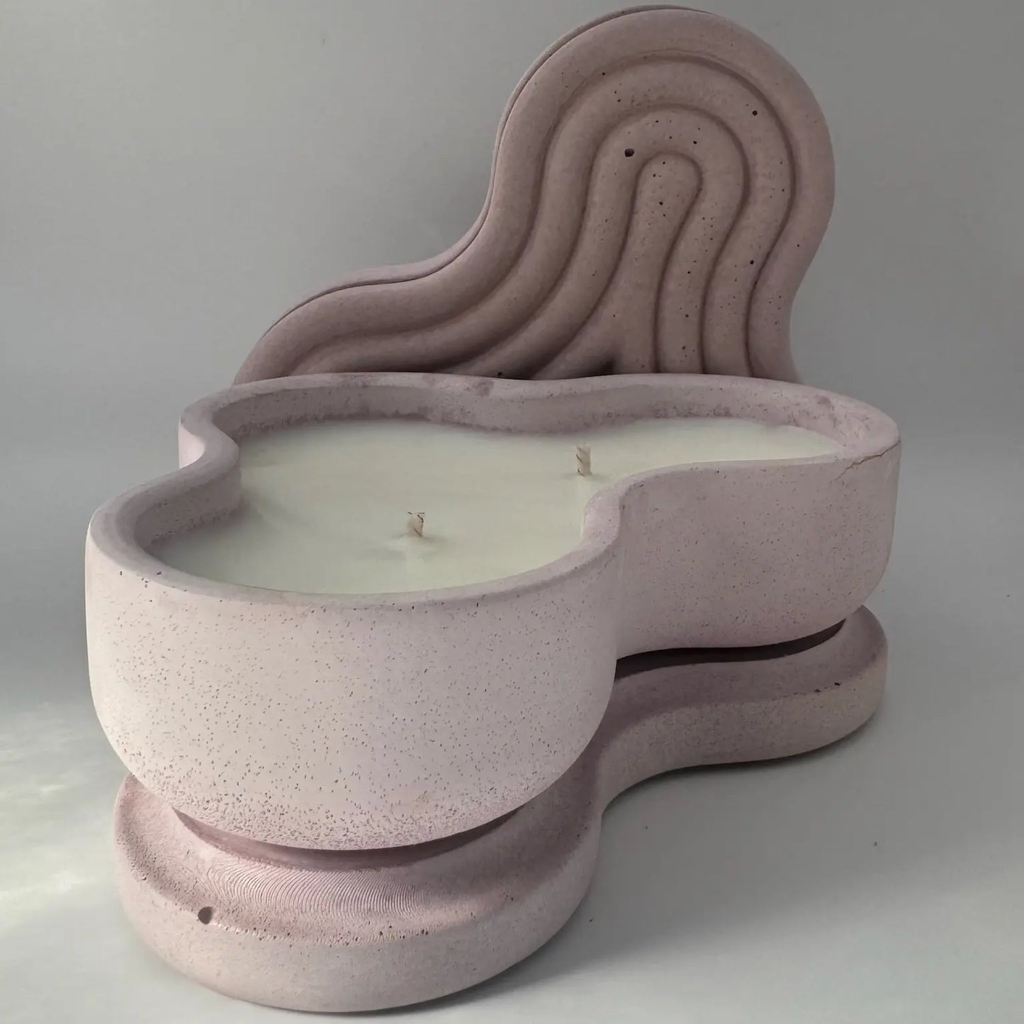 Two light purple concrete candle jars with heart-shaped designs, each featuring two cotton wicks. Set against a white background with a subtle shadow, enhancing its aesthetic appeal.